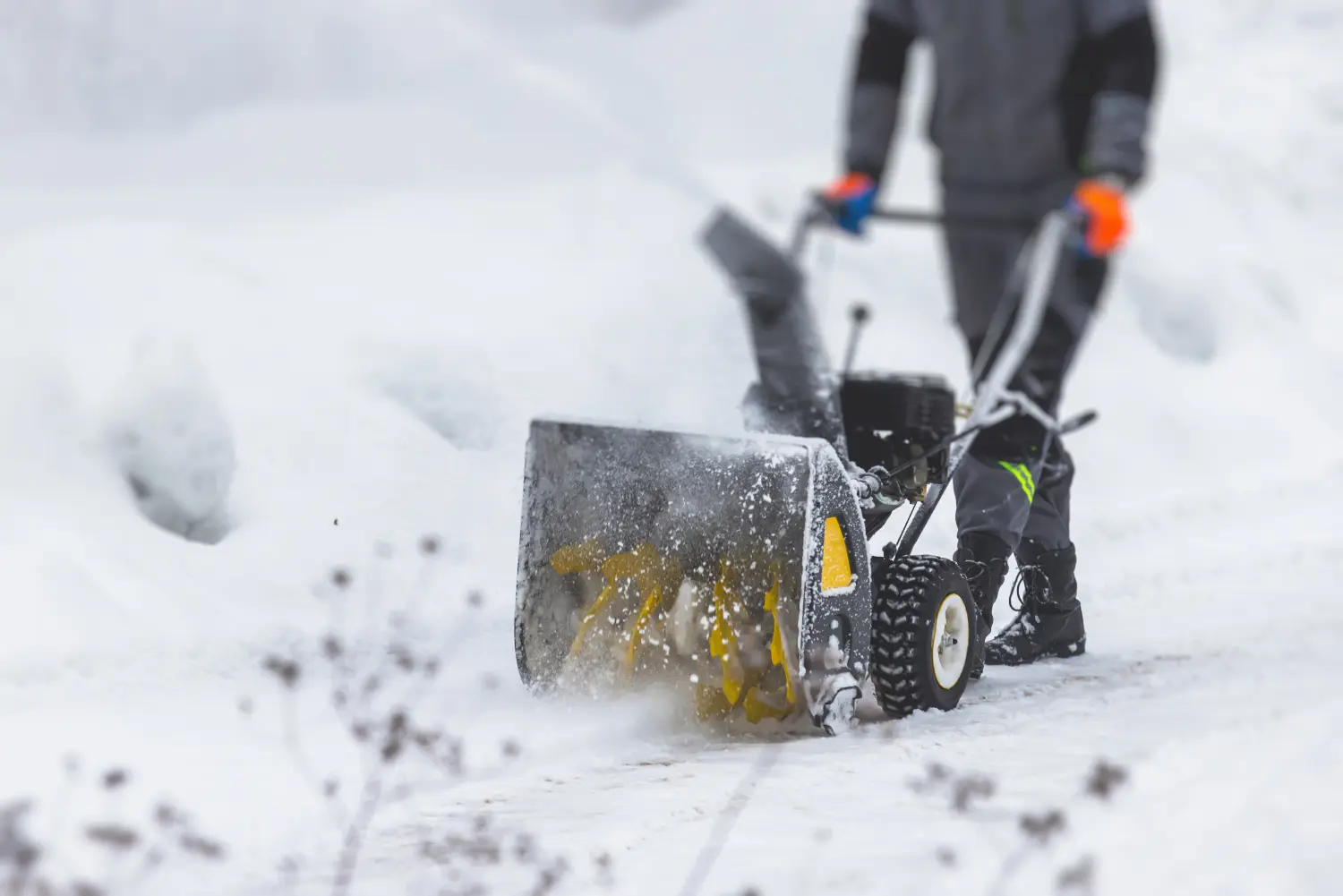 Schneeräumung mit einer tragbaren Schneefräse, Arbeiter in Arbeitskleidung mit einer Gasschneefräse auf der Straße im Winter 